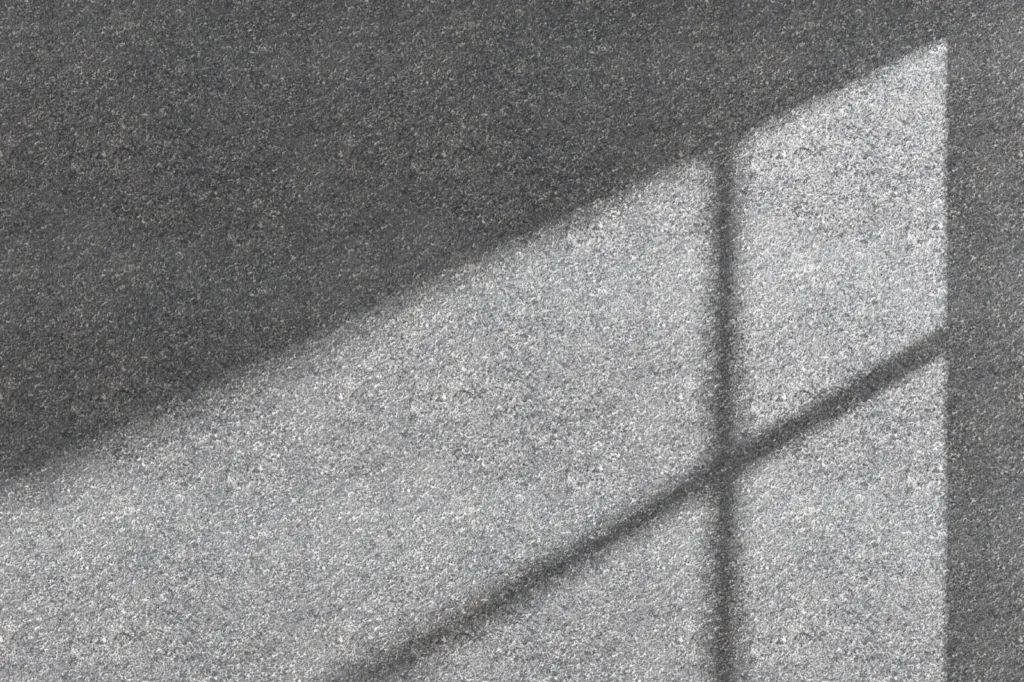 Window light falling across a plain textured wall