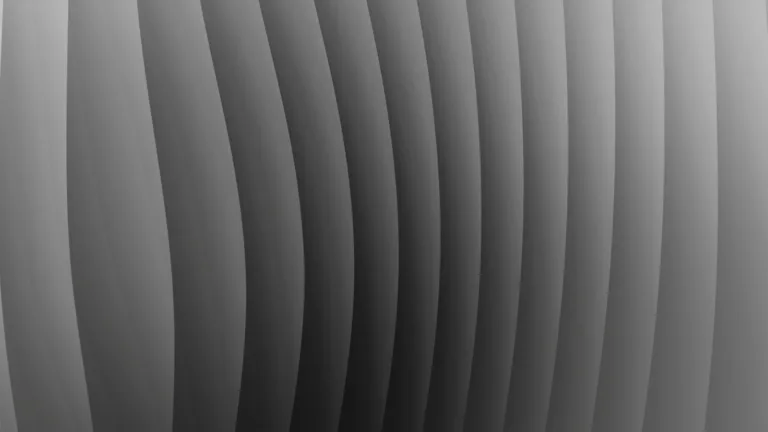 Fluted grey surface curving through gradient light