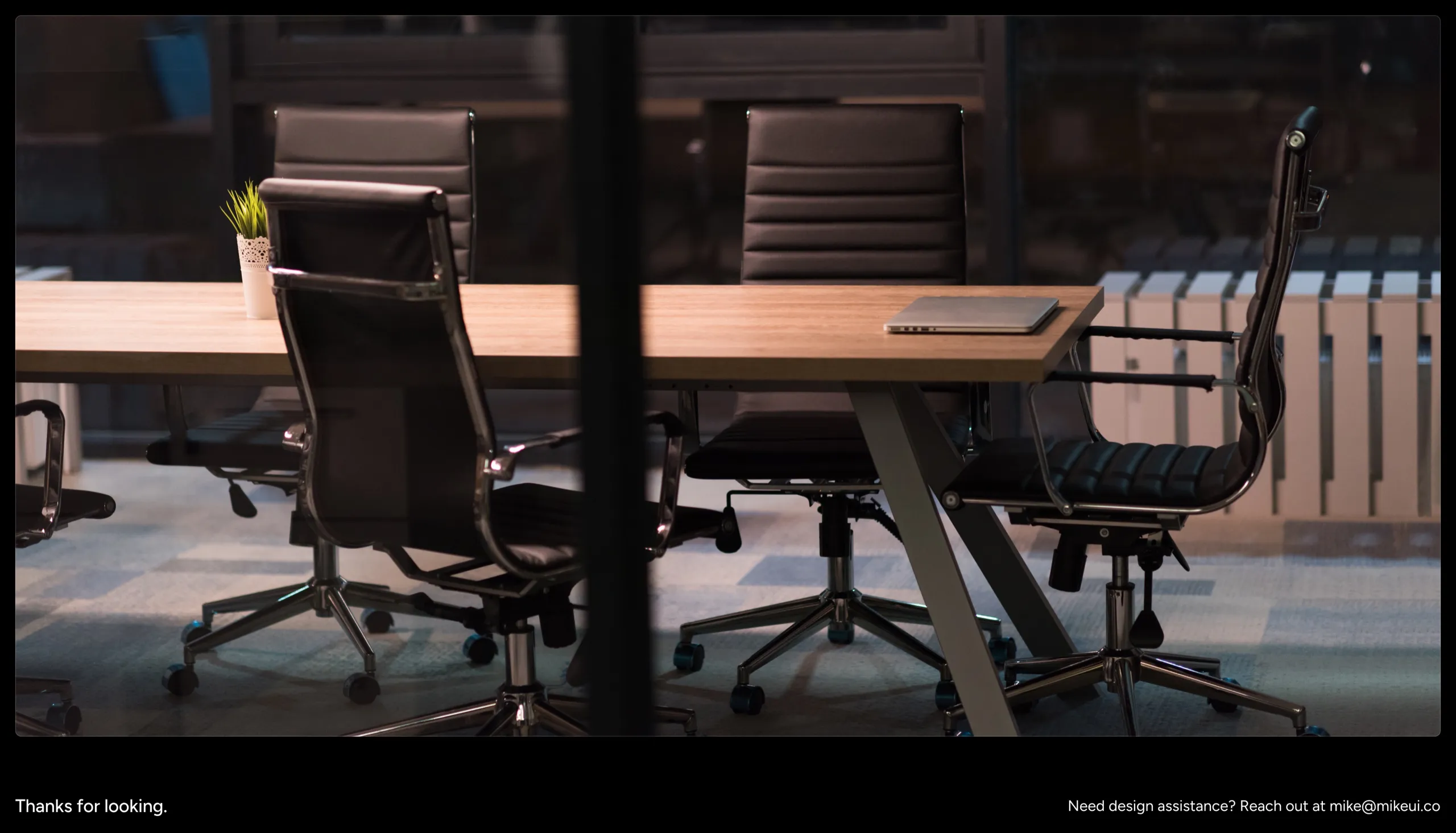 An empty meeting room at night, closing the case study with Mike's contact email
