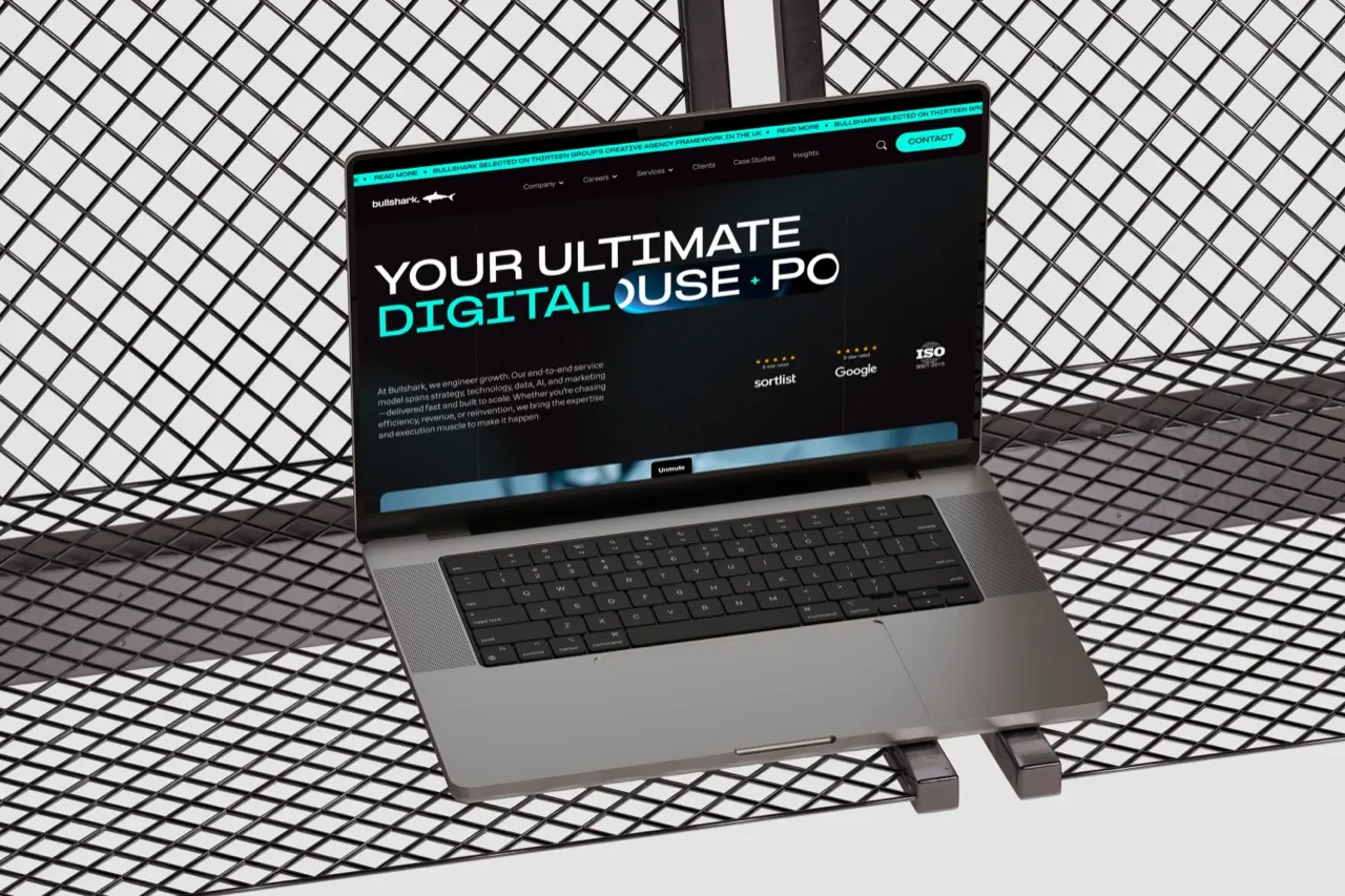 The Bullshark agency homepage, Your Ultimate Digital Powerhouse, on a MacBook Pro resting on a metal lattice