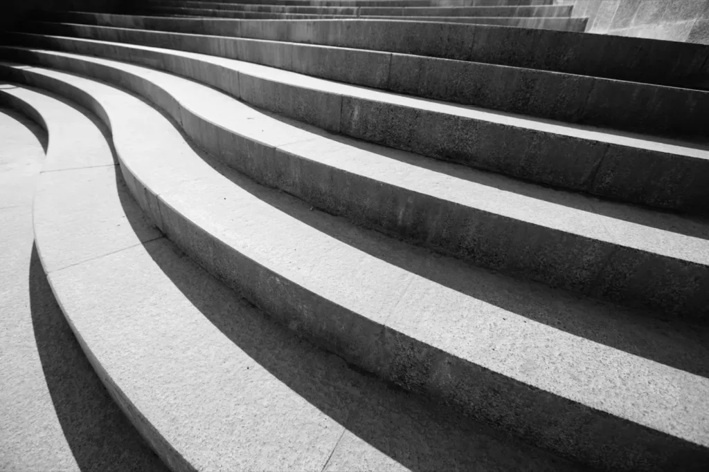 Curved concrete steps rising in a gentle arc, in black and white