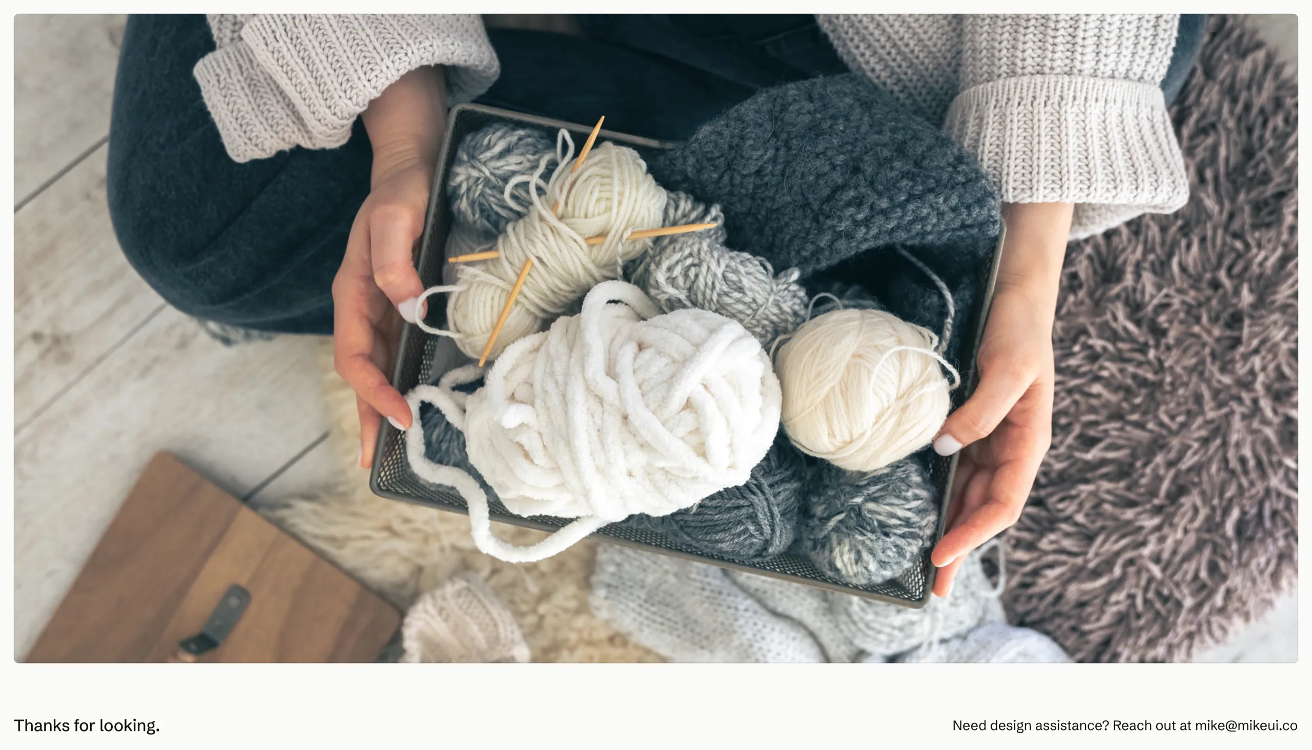 Hands holding a tray of wool skeins and knitting needles, closing the case study with Mike's contact email