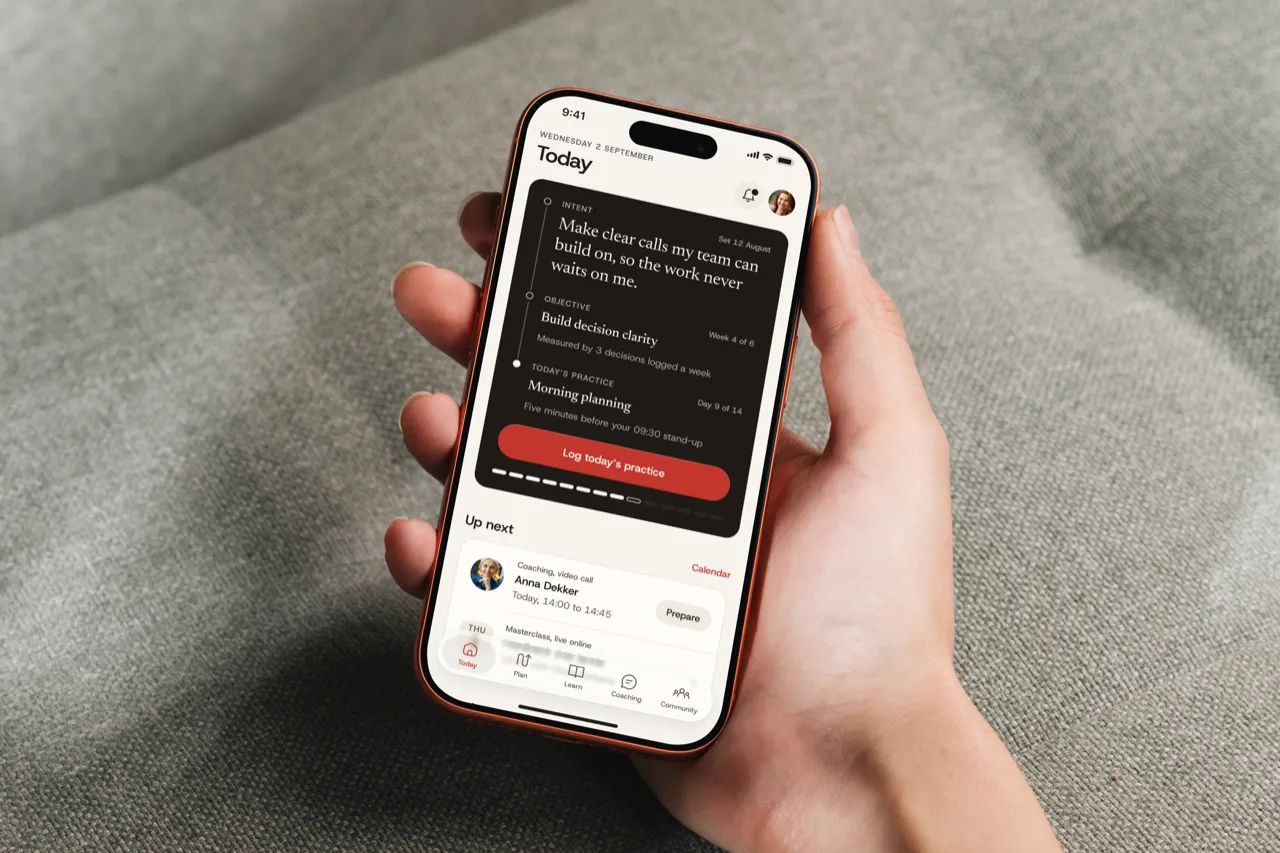 The Throughline Today screen on an iPhone held in one hand over a grey fabric sofa
