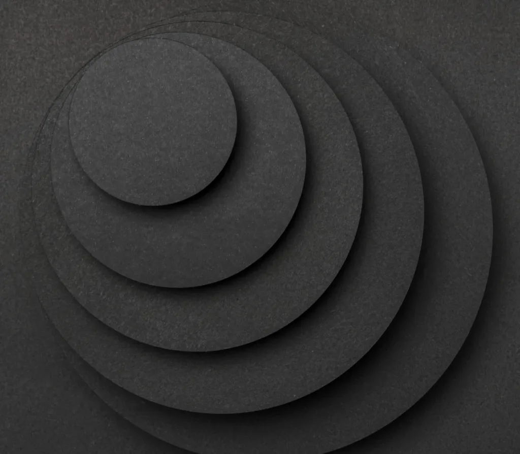 Round black paper discs stacked in levels, each one smaller than the one below it