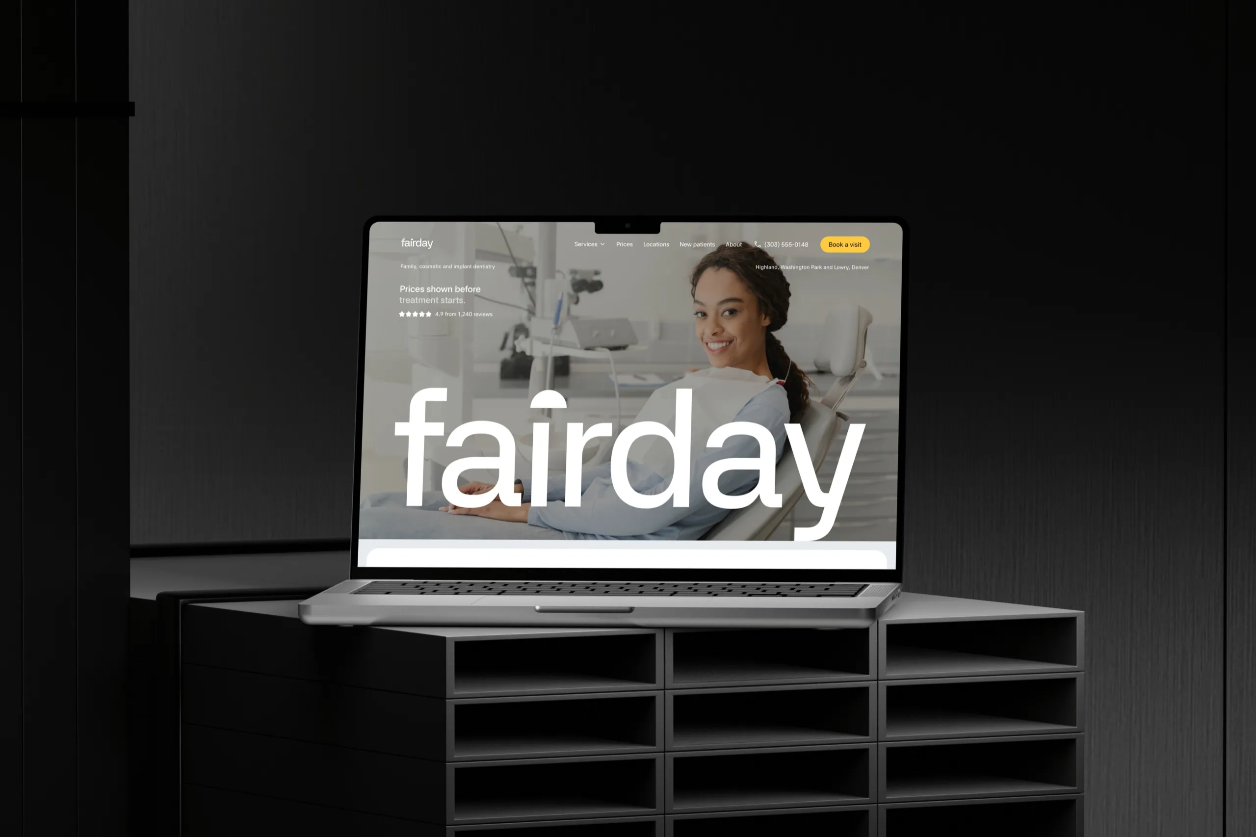 The Fairday homepage, the fairday wordmark over a patient smiling from the chair, on a MacBook Pro on a dark shelf