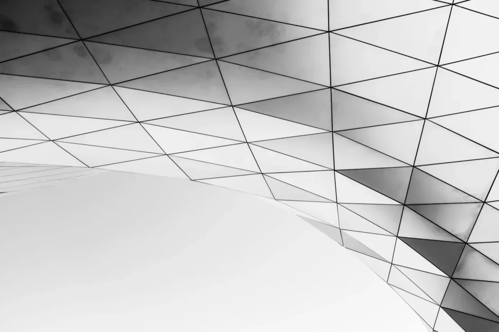 White triangular panels on the curved facade of a building, in black and white
