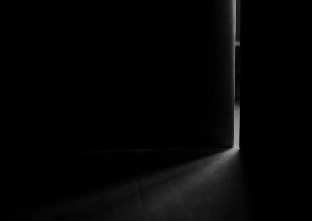 Light falling through a door left ajar into a dark room