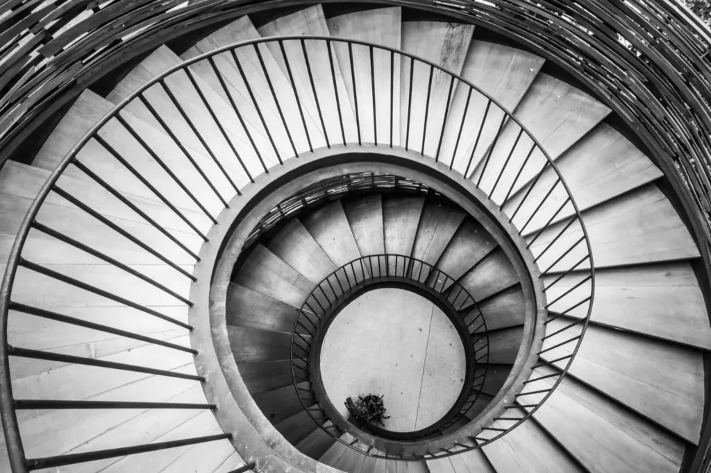 A spiral staircase seen from above, in black and white